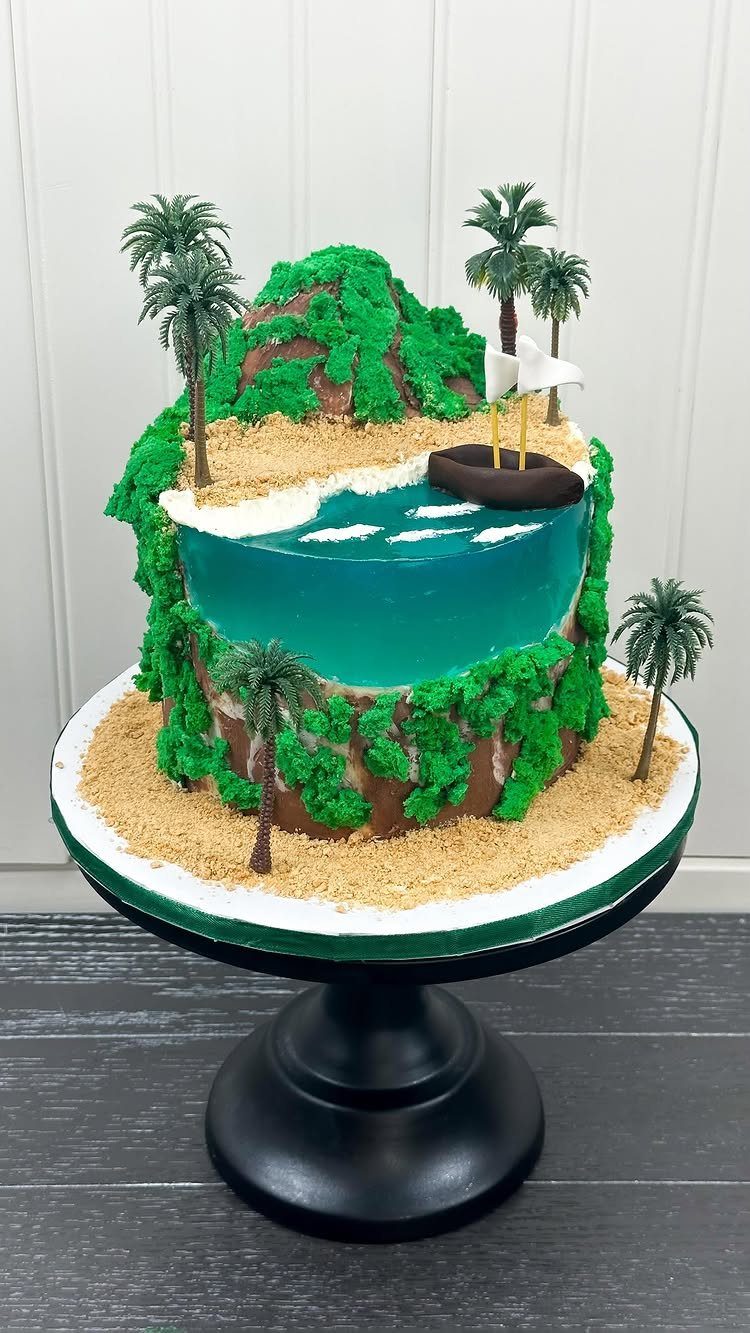26 Beach Cake Ideas with Blue Ocean Frosting to Sailboats 15 Tropical beach cake with blue water, sandy shores, palm trees, and a small boat.