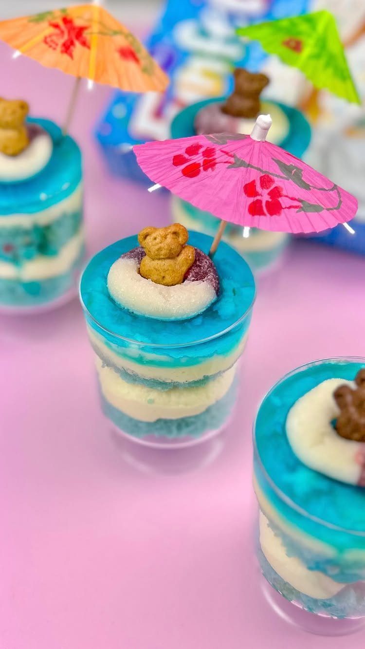 26 Beach Cake Ideas with Blue Ocean Frosting to Sailboats 23 Layered blue and white cake desserts with teddy bear cookies and pink umbrellas.