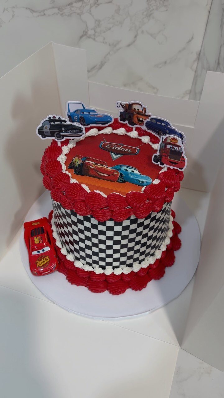 Cars movie themed birthday cake with checkered sides and Lightning McQueen photo topper.