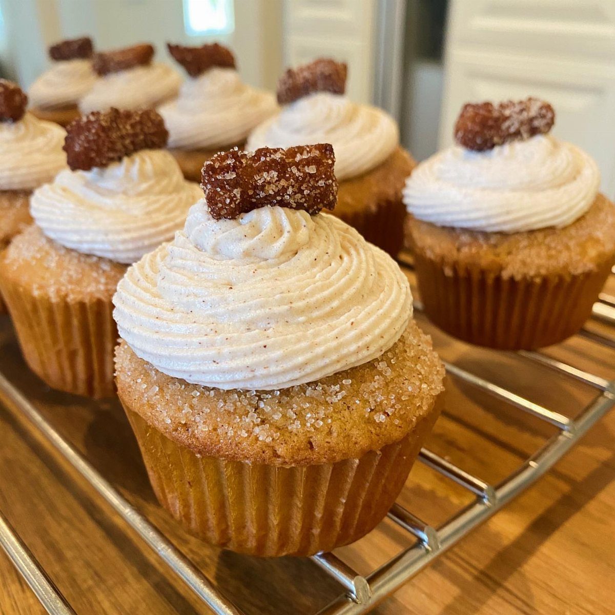 12 Cupcake Cake Ideas for Your Next Celebration 13 Churro cupcakes with cinnamon buttercream frosting and churro pieces on a wire rack.