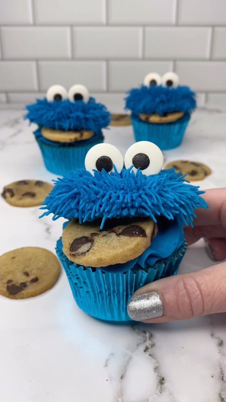 12 Cupcake Cake Ideas for Your Next Celebration 10 Cookie Monster cupcakes with blue frosting and chocolate chip cookies in their mouths.