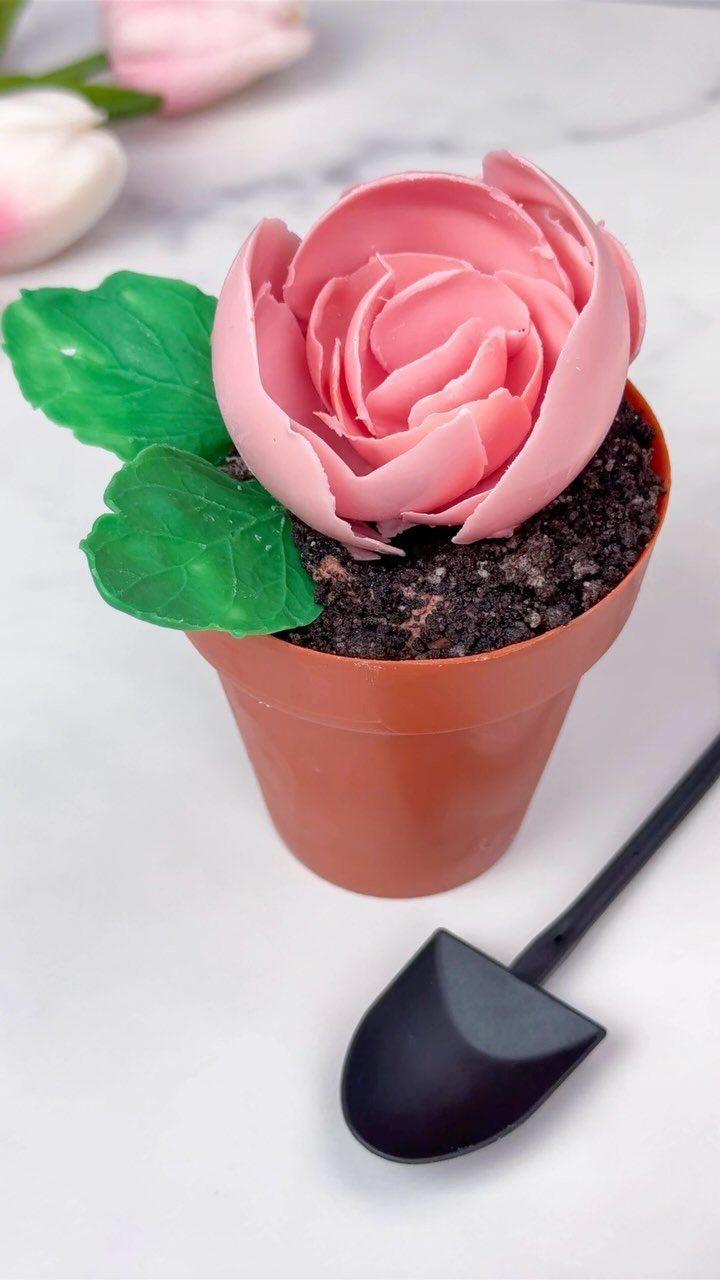 12 Cupcake Cake Ideas for Your Next Celebration 9 Pink rose cupcake in a small terracotta pot with chocolate soil and a shovel.