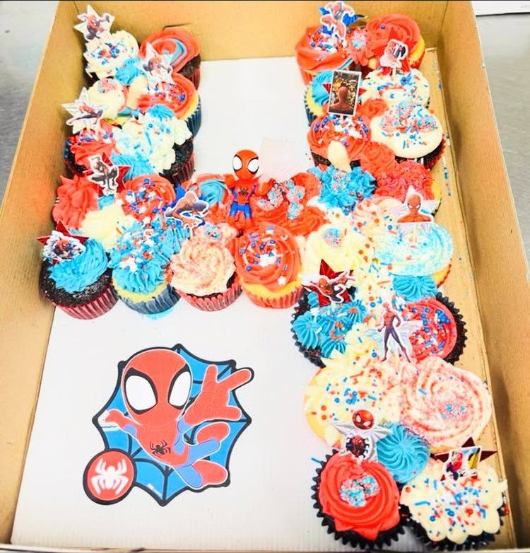 12 Cupcake Cake Ideas for Your Next Celebration 11 Spider-Man themed pull-apart cupcake cake with red and blue frosting and character toppers.