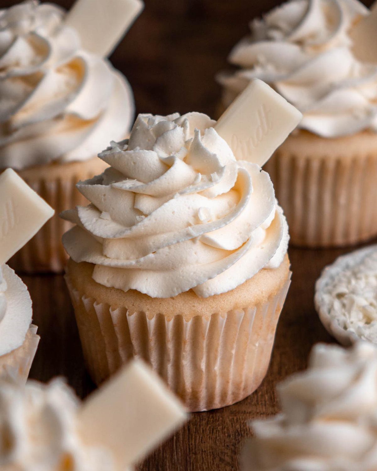12 Cupcake Cake Ideas for Your Next Celebration 3 White chocolate cupcakes with swirls of white frosting and white chocolate squares.