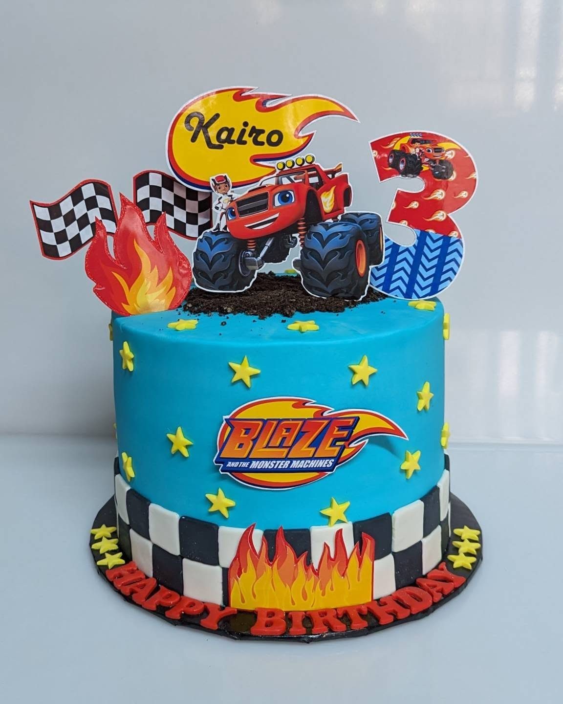 Blue Blaze and the Monster Machines birthday cake with red truck toppers and stars.