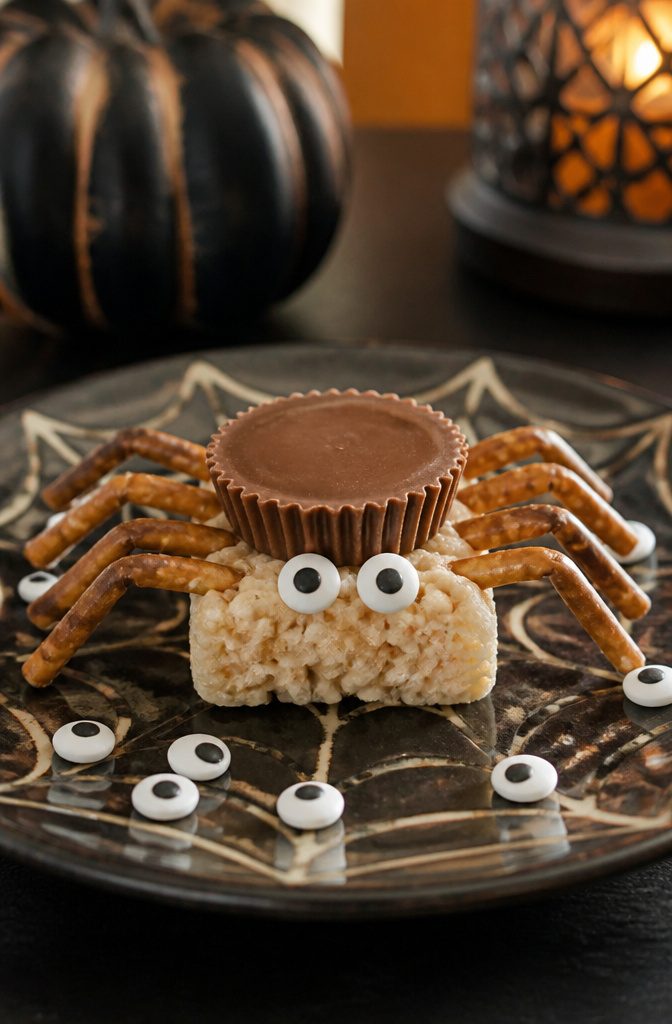 A Rice Krispie treat decorated with a Reese's Cup and chocolate legs.
