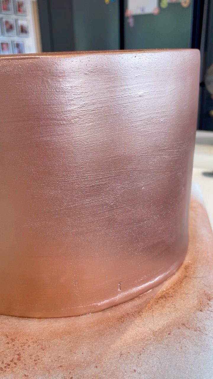 Rose gold metallic cake with smooth frosting on a matching cake board.