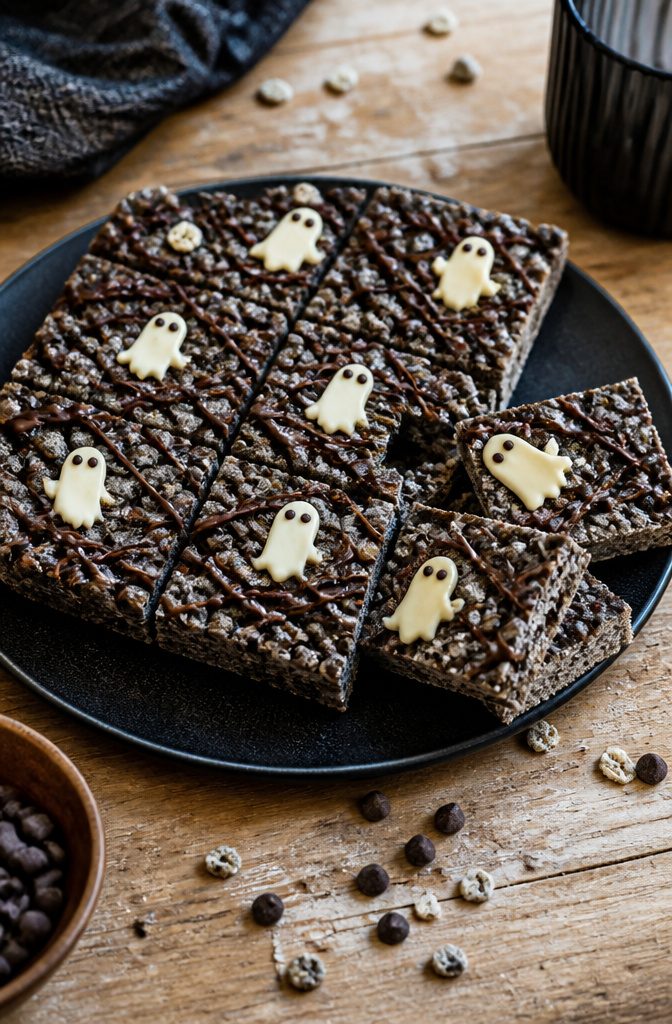 16 Wednesday Snack Ideas for 2026: Dark, Sweet and Savory 5 A slab of dark rice cereal treats on a black plate.