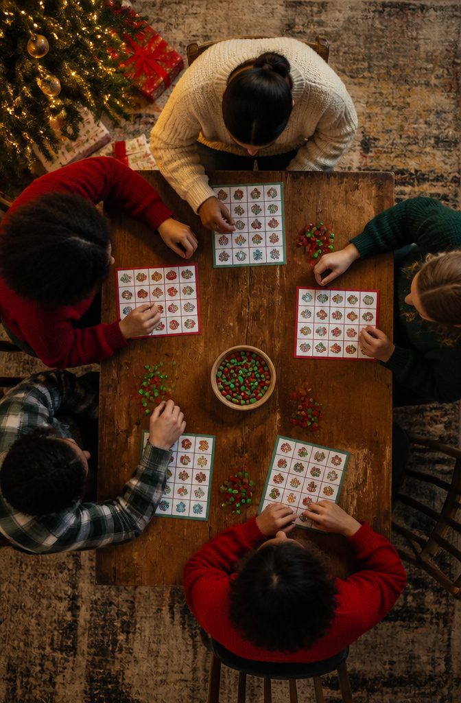 15 Xmas Party Ideas & Games for 2026 Celebrations 10 Bingo cards featuring Christmas symbols laid out on a table for players.